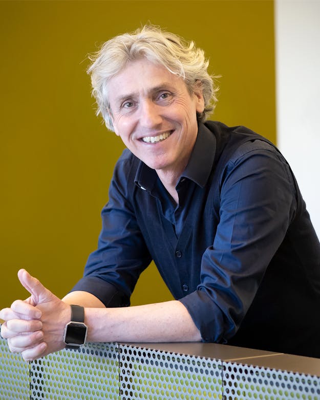 Reint Jan Renes. Reint Jan Renes leunend op een balustrade.