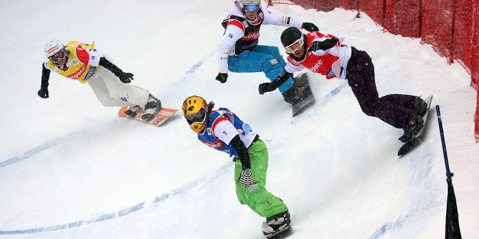 Een groep mensen snowboardt een helling af.