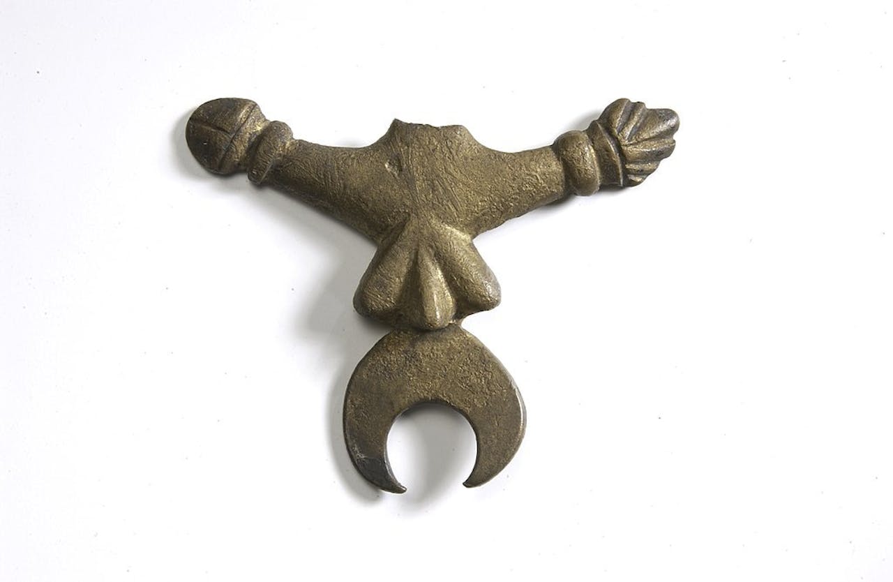 Een koperen amulet in de vorm van een fallus.