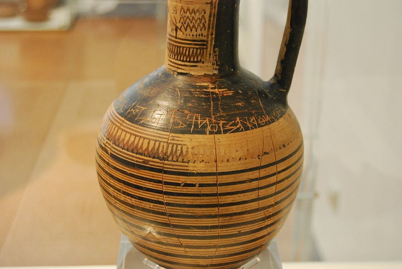 Een zwart-bruine vaas tentoongesteld in een museum.