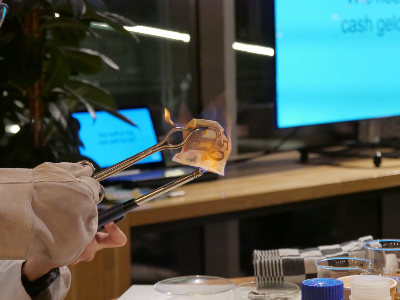 De avond begon met een klein experiment: het ‘verbranden’ van een briefje van 50. Gedrenkt in een mengsel van alcohol en water ontstaan er wel vlammen, maar verbrandt het geld niet echt. Echt geld verbranden is zelfs strafbaar.