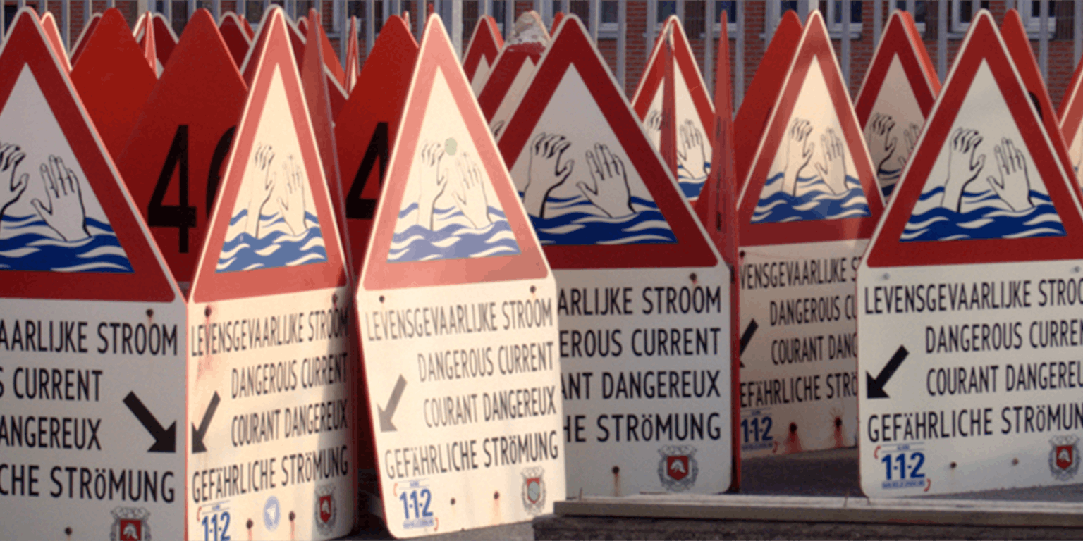 Een groep waarschuwingsborden. Op het bord staat de waarschuwing: Levensgevaarlijkse stroom.