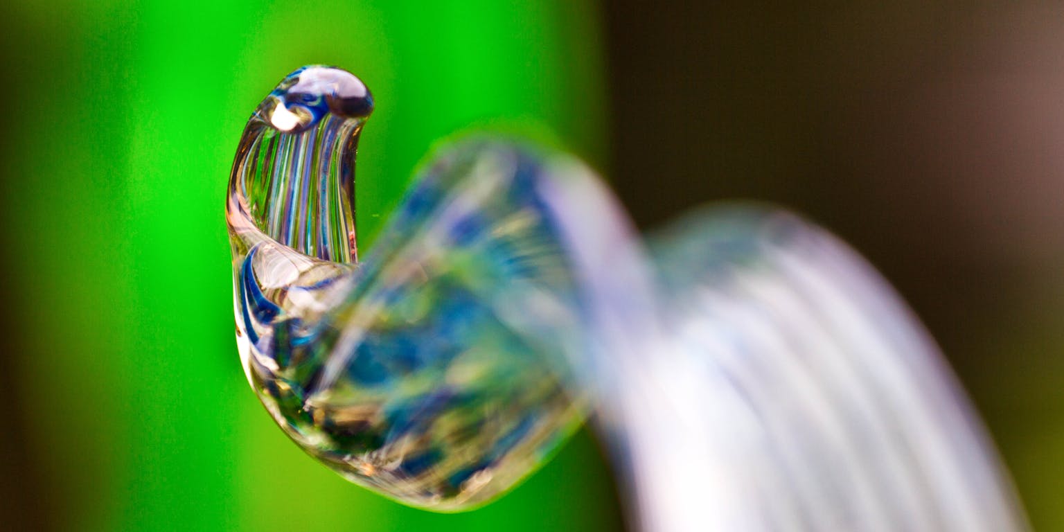 Gekleurd en gekrult glas op een groene achtergrond.