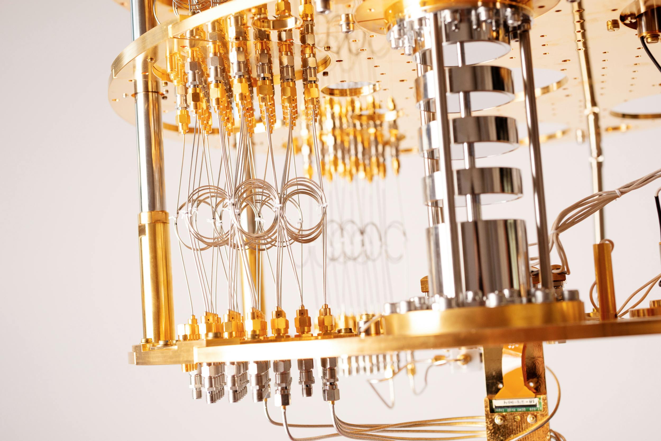 Een close-up van een quantum computer met veel draden en gouden elementen.