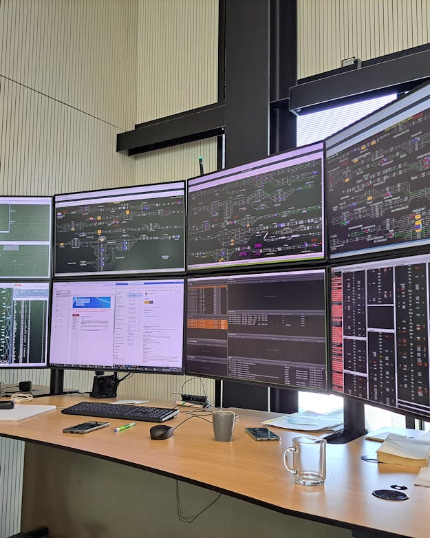 Op een dubbele rij beeldschermen houdt de hoofdverkeersleiding van ProRail al het goederenverkeer op de Nederlandse spoorwegen in de gaten, en stuurt het treinverkeer bij als dat nodig is. Een bureau met twee rijen beeldschermen, acht in totaal. Op de beeldschermen is allerlei data te zien