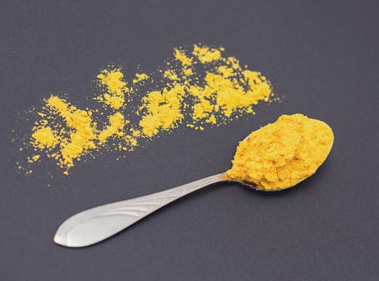 Lepel met kurkuma-poeder