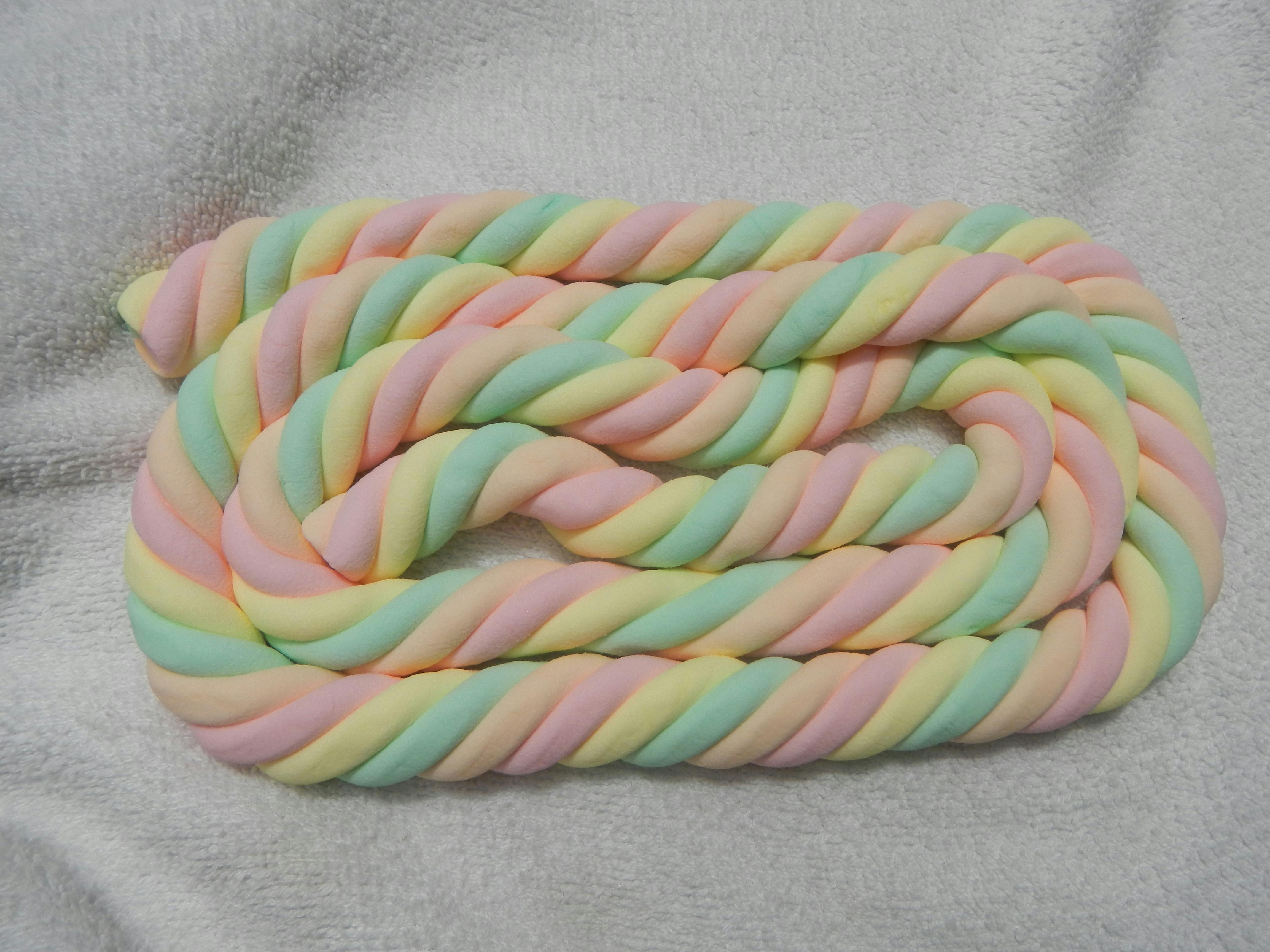 Een kronkel van pastelkleurig spek ligt op een witte deken.