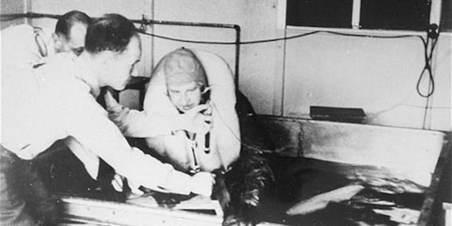 Afbeelding van experiment in concentratiekamp waarin twee mannen en derde man in een pilotenpak in een ijsbad helpt.