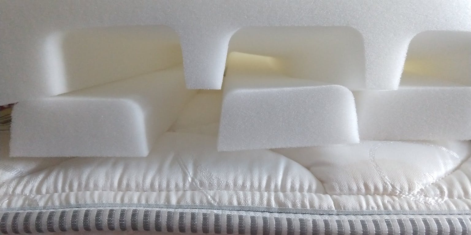 Verschillende lagen materiaal van een matras op elkaar gestapeld.