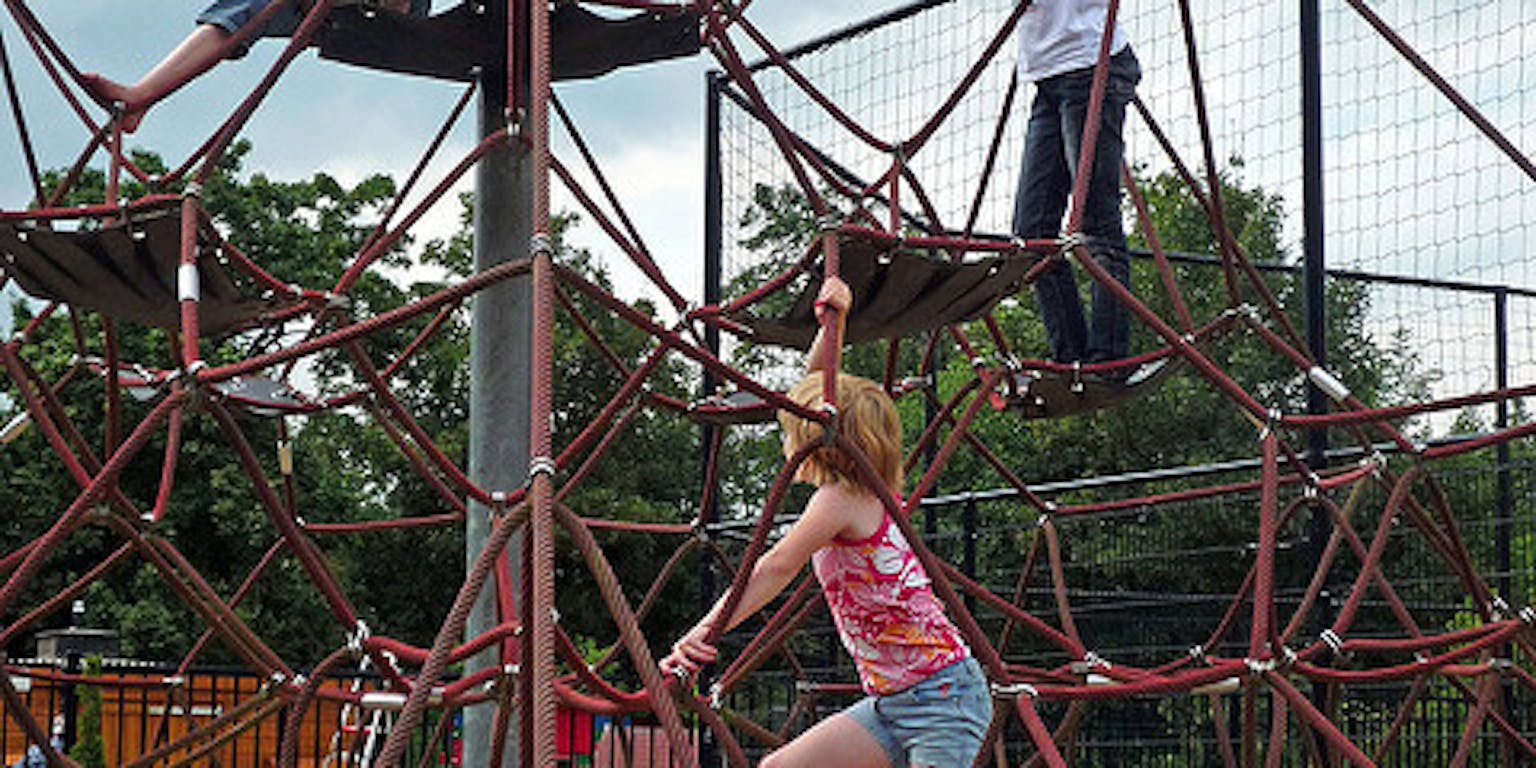 Een groep kinderen speelt op een klimrek.
