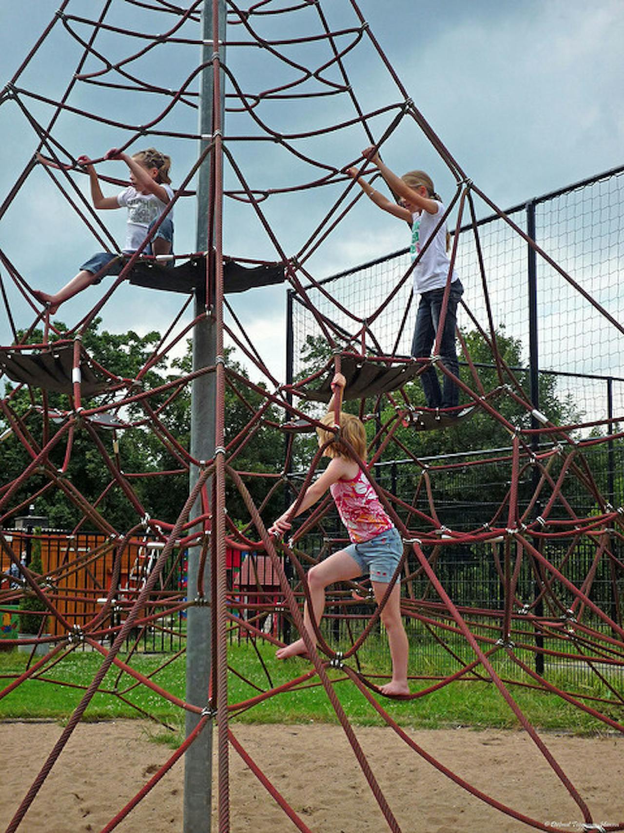 Een groep kinderen speelt op een klimrek.