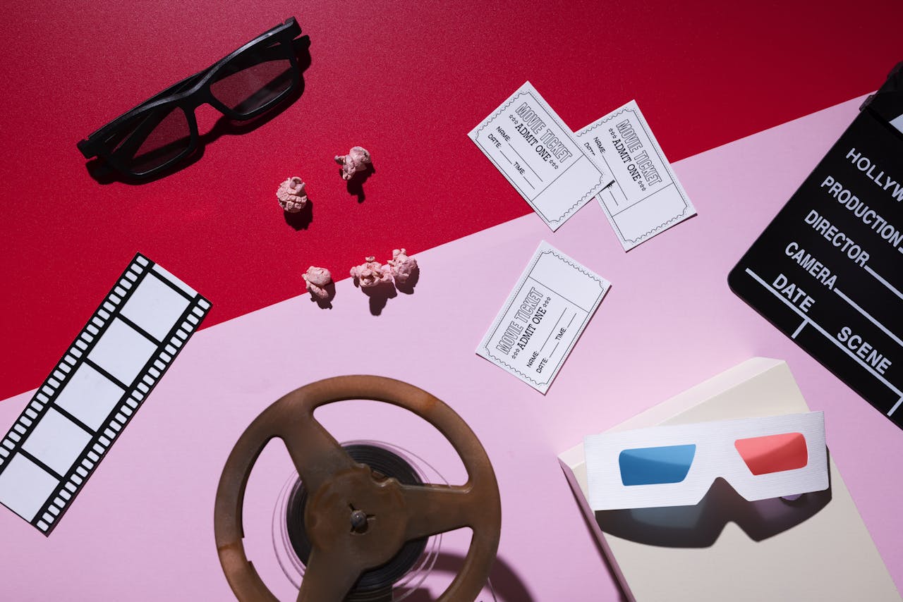 stilleven van filmattributen met filmkaartjes, roze popcorn en 3d-brillen