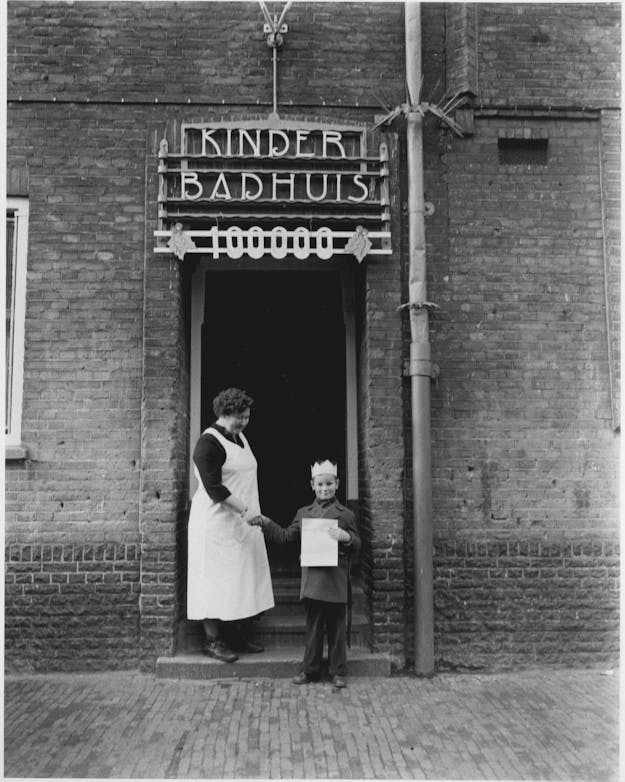 Een badhuis in Amsterdam verwelkomt in 1953 het honderdduizendste kind dat jaar.