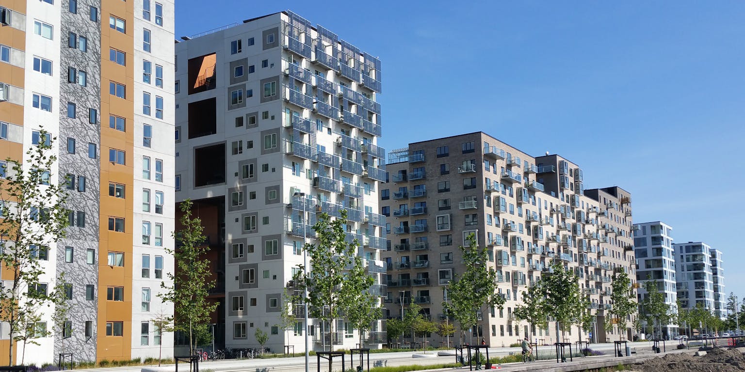 Een rij appartementsgebouwen naast een rivier.