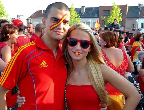 Twee personen poseren voor een foto. Beide personen zijn gekleed in het rood.