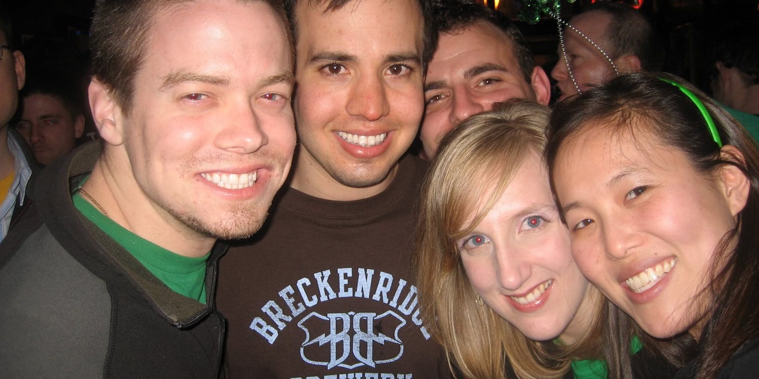 Een groep mensen poseert voor een foto in een bar.