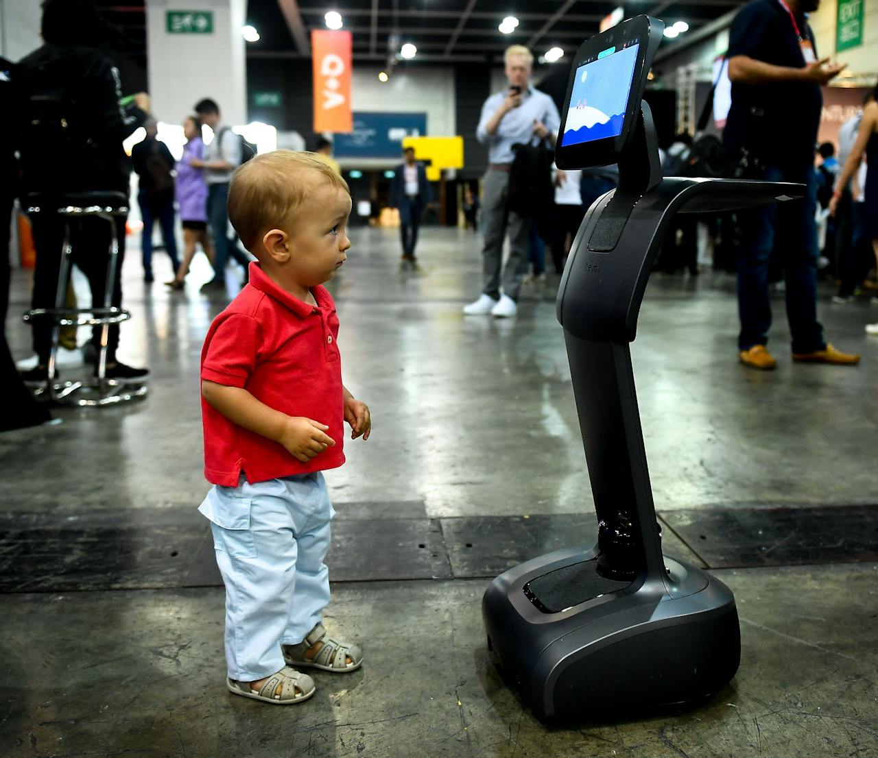 Een kind staat voor een robot.