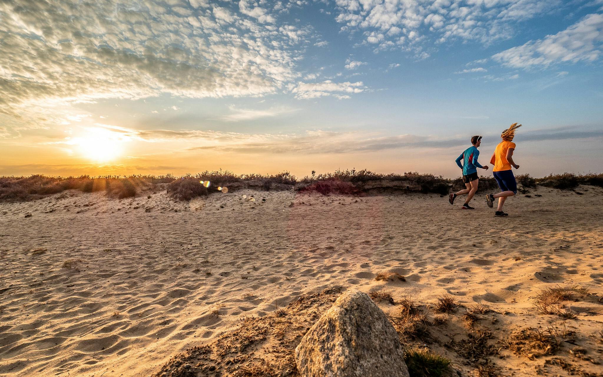 Bij zonsondergang rent een man over het strand.