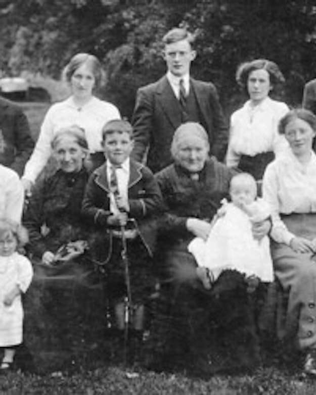 Zwart-wit foto van een familie aan het begin van de 20e eeuw met in totaal 12 mensen.