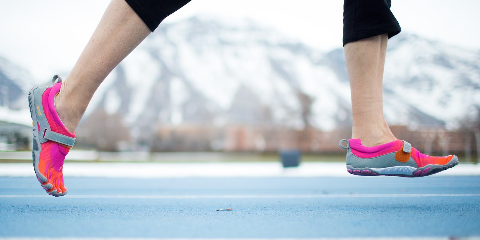 Een persoon die hardloopt op een atletiekbaan.