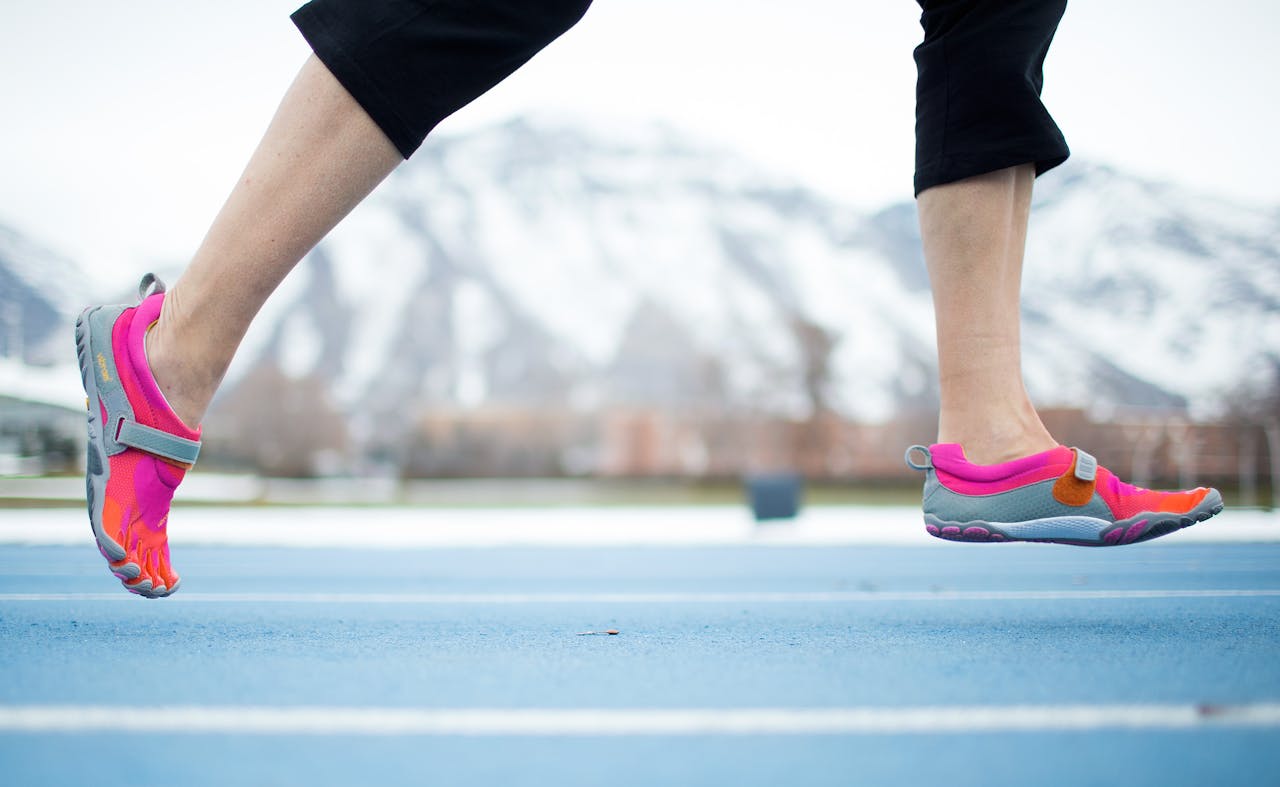 Een persoon die hardloopt op een atletiekbaan.