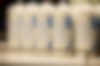 Close-up van witte kaarsen met daarop een blauwe bloem en de blauwe tekst 'Moge de data zachtjes rusten'.