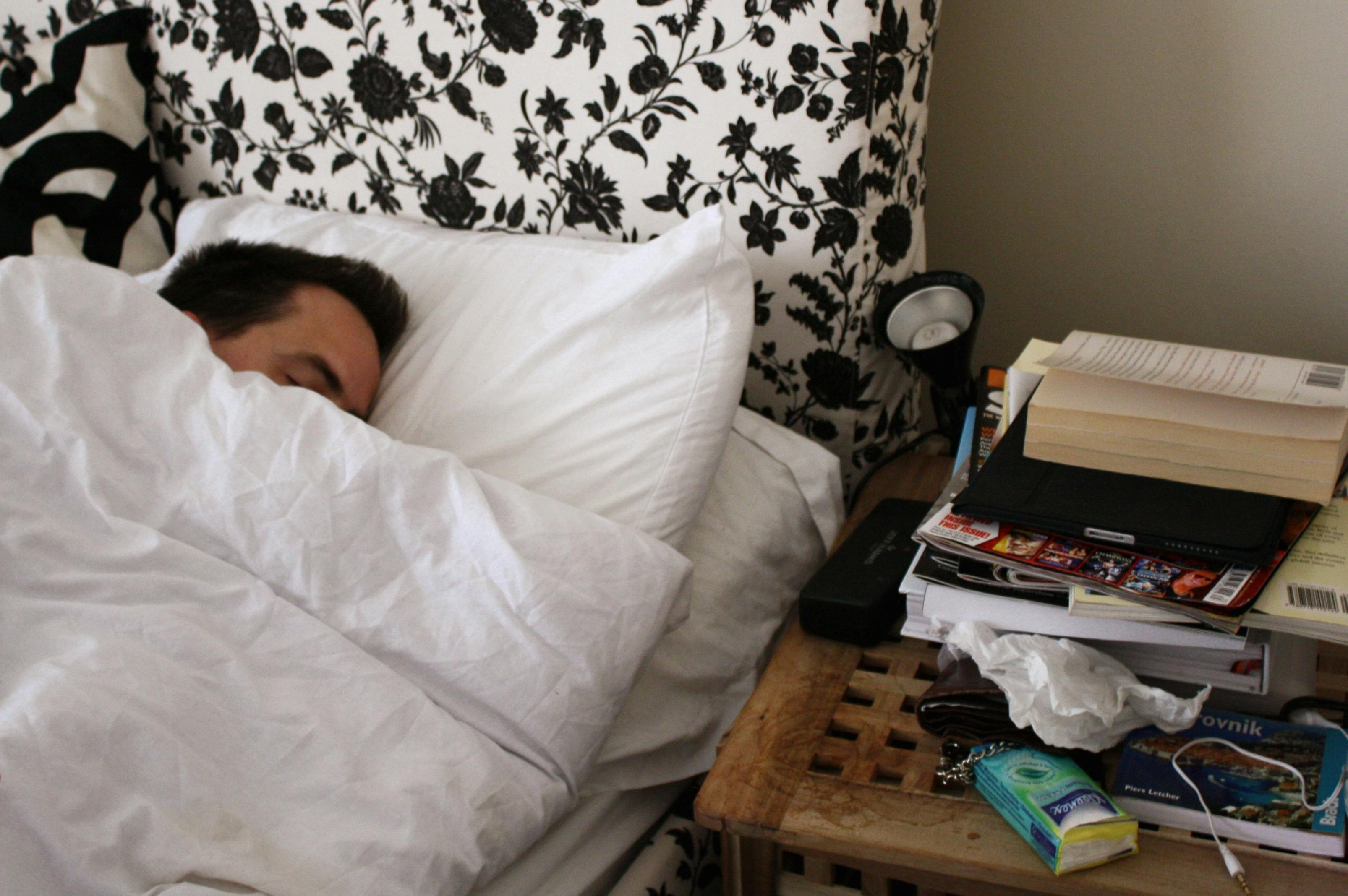 Een man slaapt op een bed.