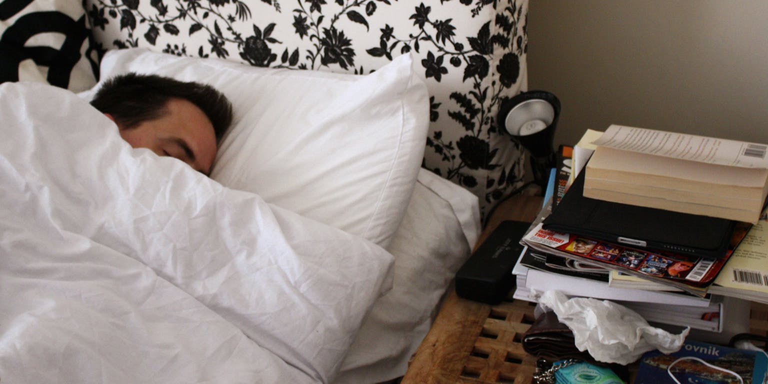 Een man slaapt op een bed.