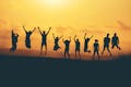 Silhouet van tien mensen die in de lucht springen tegen de achtergrond van een ondergaande zon