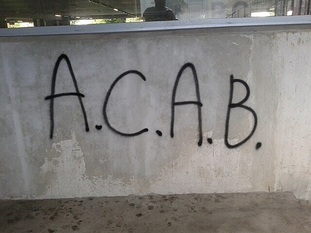 Een muur met daarop de letters A.C.A.B. gespoten met graffiti.