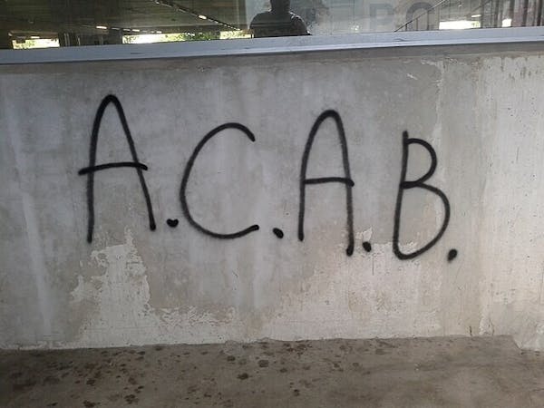 Een muur met daarop de letters A.C.A.B. gespoten met graffiti.
