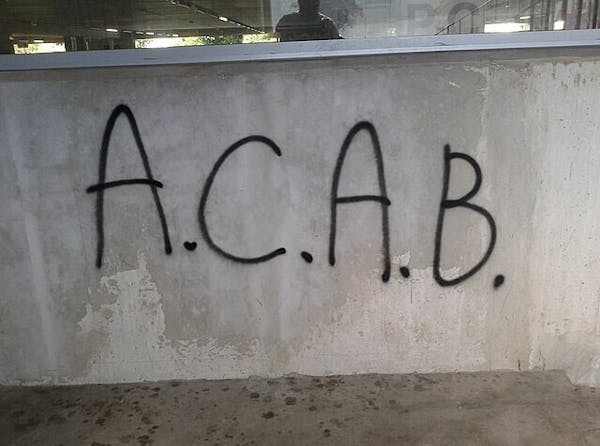 Een muur met daarop de letters A.C.A.B. gespoten met graffiti.