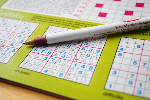 Alleen als je de ene groep wél sudoku's laat maken en de andere niet, kun je onderzoeker wat het effect is op het geheugen Een sudokuboek met een pen erop.