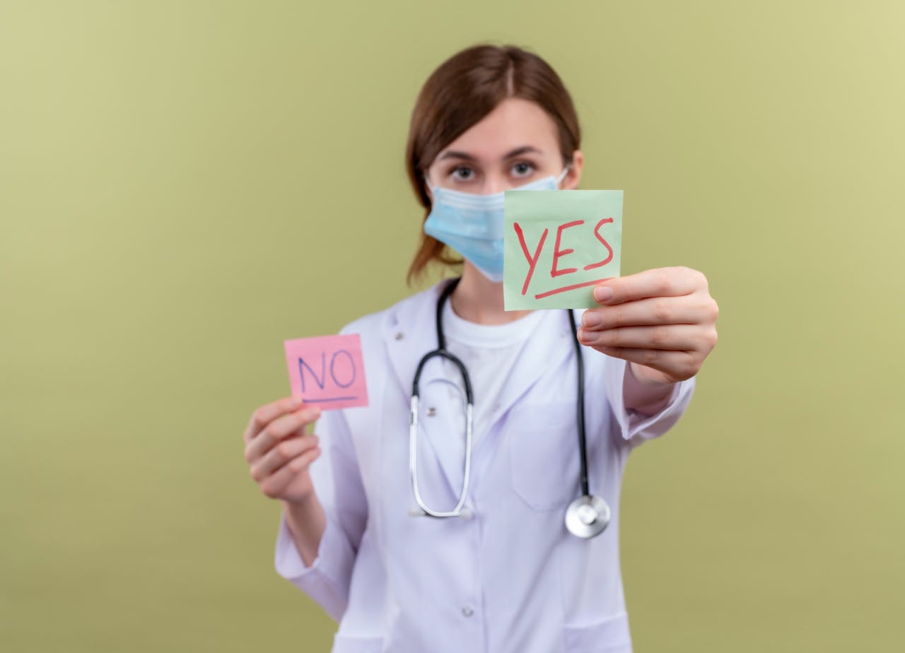 Wanneer gentherapie gewenst of verantwoord is, is niet eenduidig. medische ethiek in de vorm van een jonge vrouw met mondkapje en witte doktersjas die een papiertje met yes en een papiertje met no vasthoudt