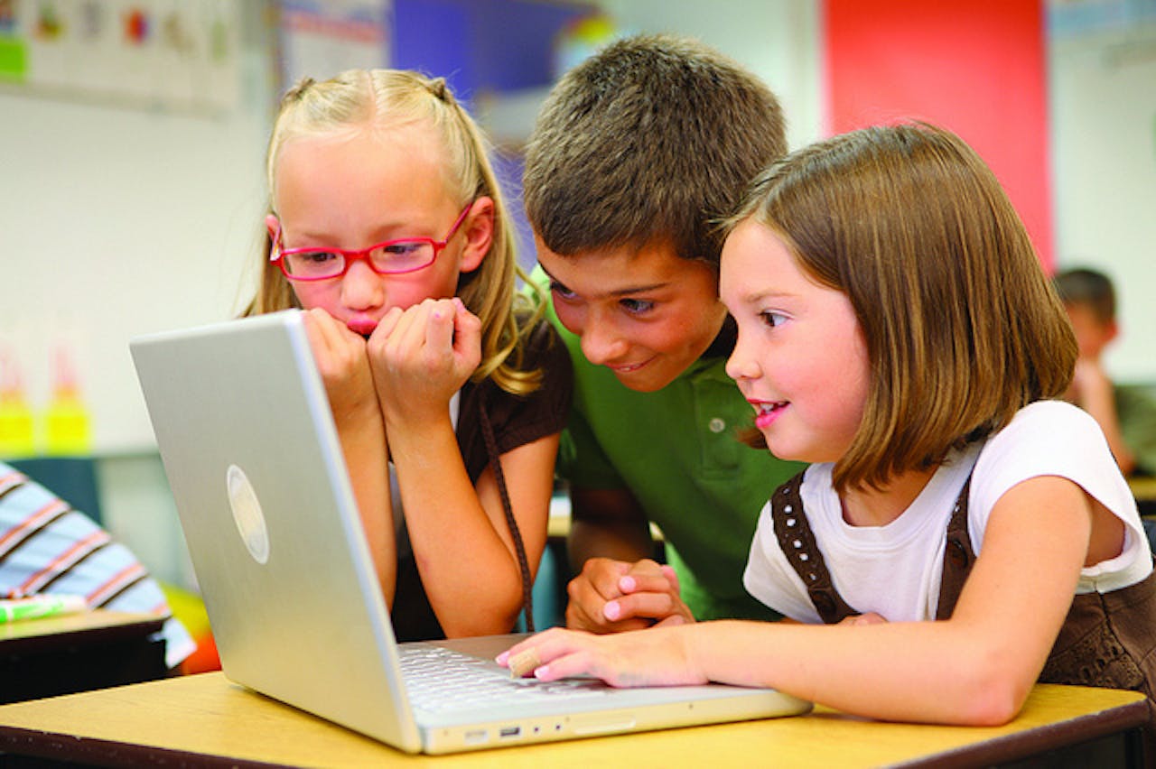 Een groep kinderen kijken naar een laptop.