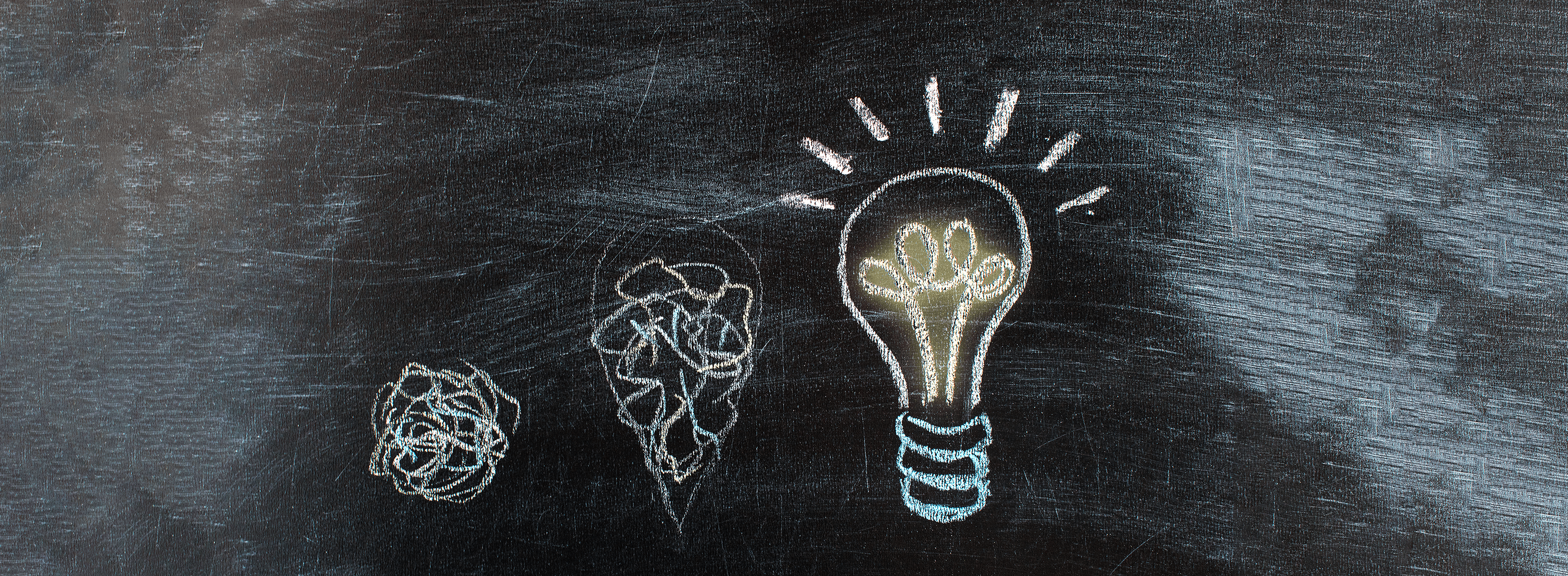 Op een schoolbord staat een gloeilamp getekend.