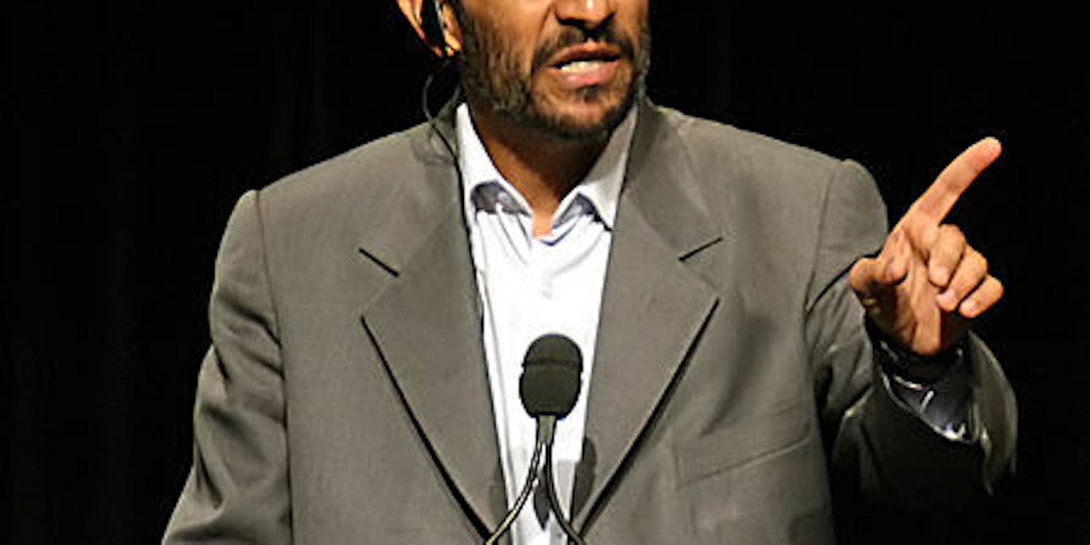 Een foto van Mahmoud Ahmadinejad, de vormalig president van Iran. Hij houdt een toespraak.