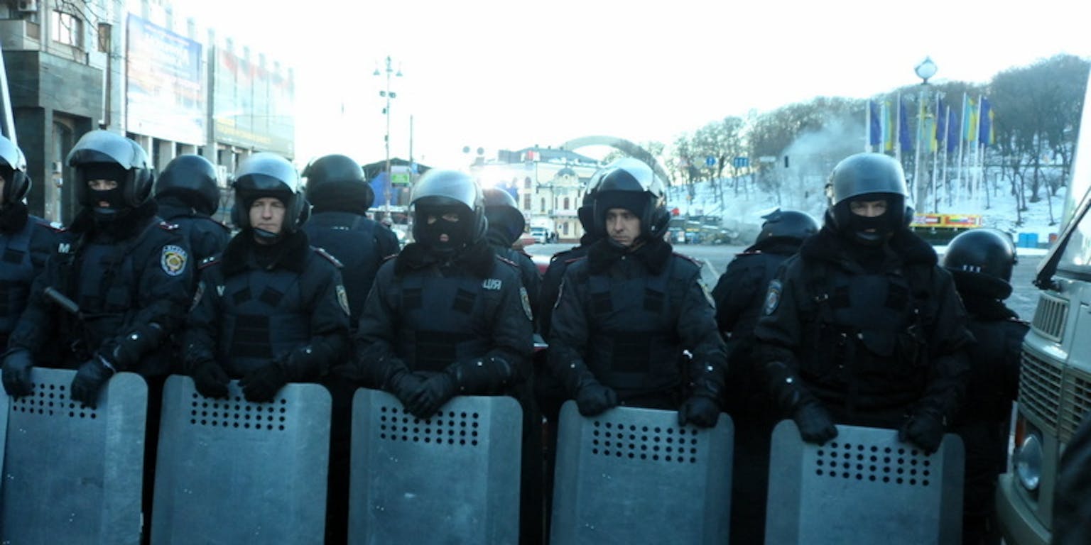 Een groep oproerpolitie staat naast elkaar.