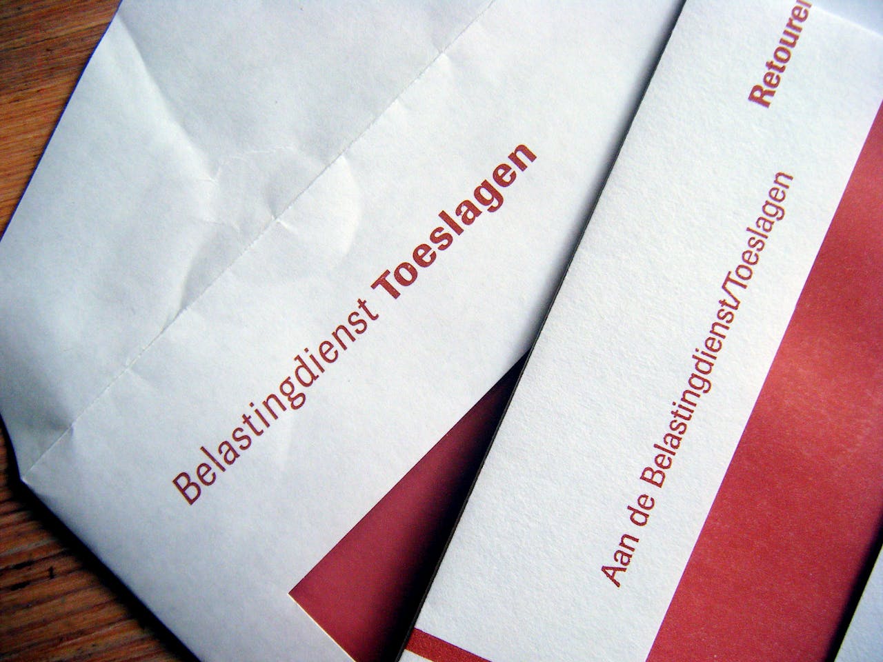 Bij de Toeslagenaffaire speelde gebrekkige digitale kennis een grote rol. Een witte envelop met daarop de rode tekst 'Belastingdienst Toeslagen' en een witte envelop met de tekst 'Aan de Belastingsdienst/Toeslagen'. Maar een deel van de enveloppen zijn zichtbaar.