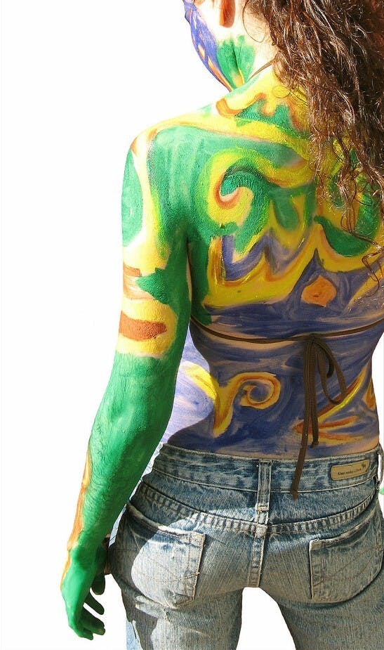 Een vrouw met kleurrijke bodypaint op haar rug.