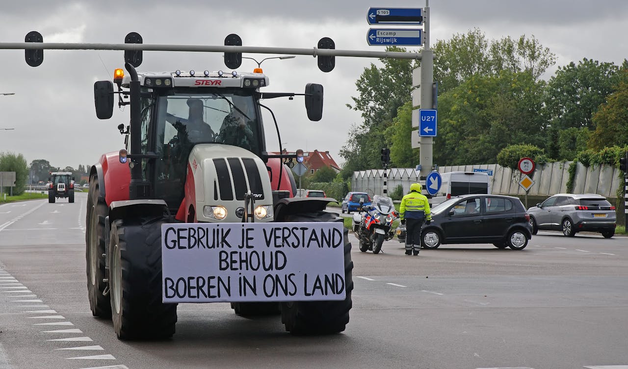 Een herkenbaar beeld van een boerenprotest: een tractor met een bord waarop staat 'Gebruik je verstand, behoud boeren in ons land'.