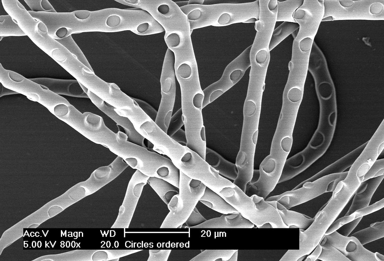 Gestempelde cirkelpatronen op de microvezels, gezien door een elektronenmicroscoop.