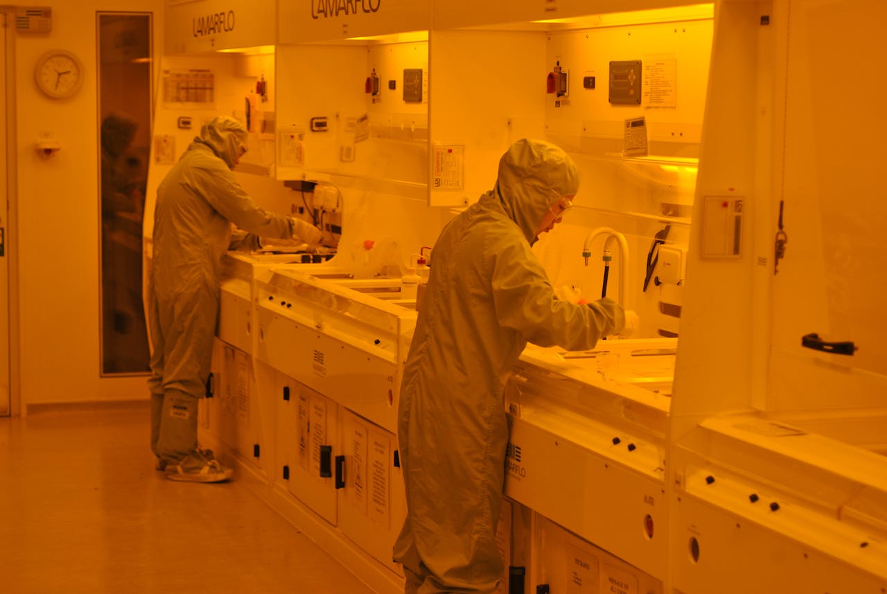 Twee mensen aan het werk in een cleanroom. Een cleanroom is een gecontroleerde omgeving, waar micro-organismen actief worden geweerd.