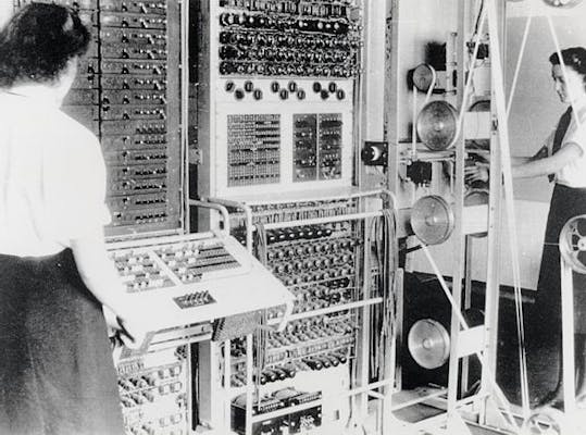 Twee vrouwen voor de Colussus Mark 2 computer die groter is dan de vrouwen zelf.