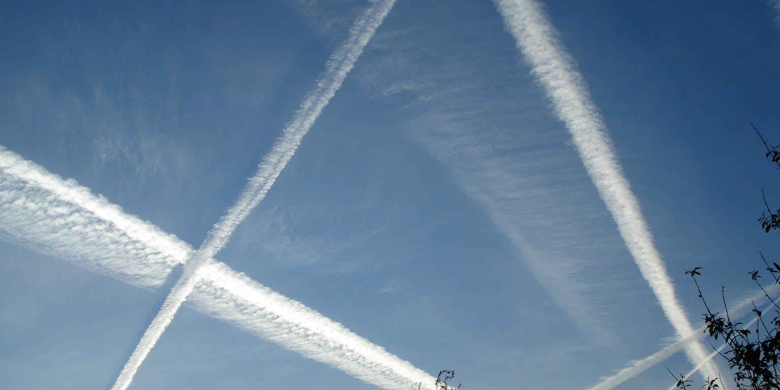 Vliegtuigstrepen in de blauwe lucht.