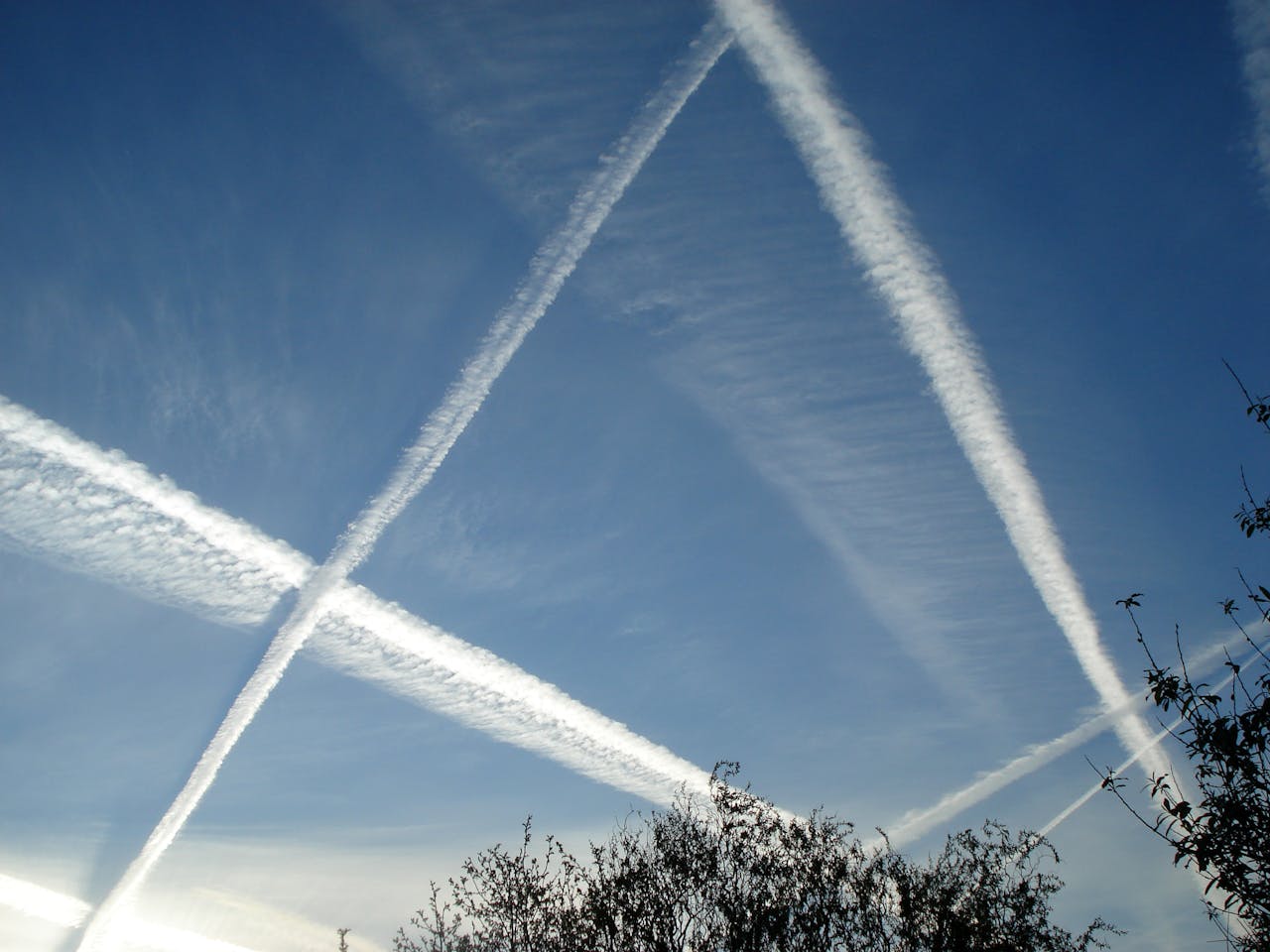 Vliegtuigstrepen in de blauwe lucht.