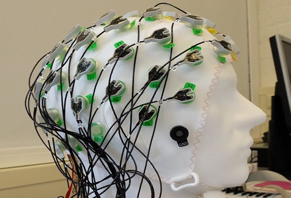 Een mannequinhoofd met daaraan bevestigde draden.