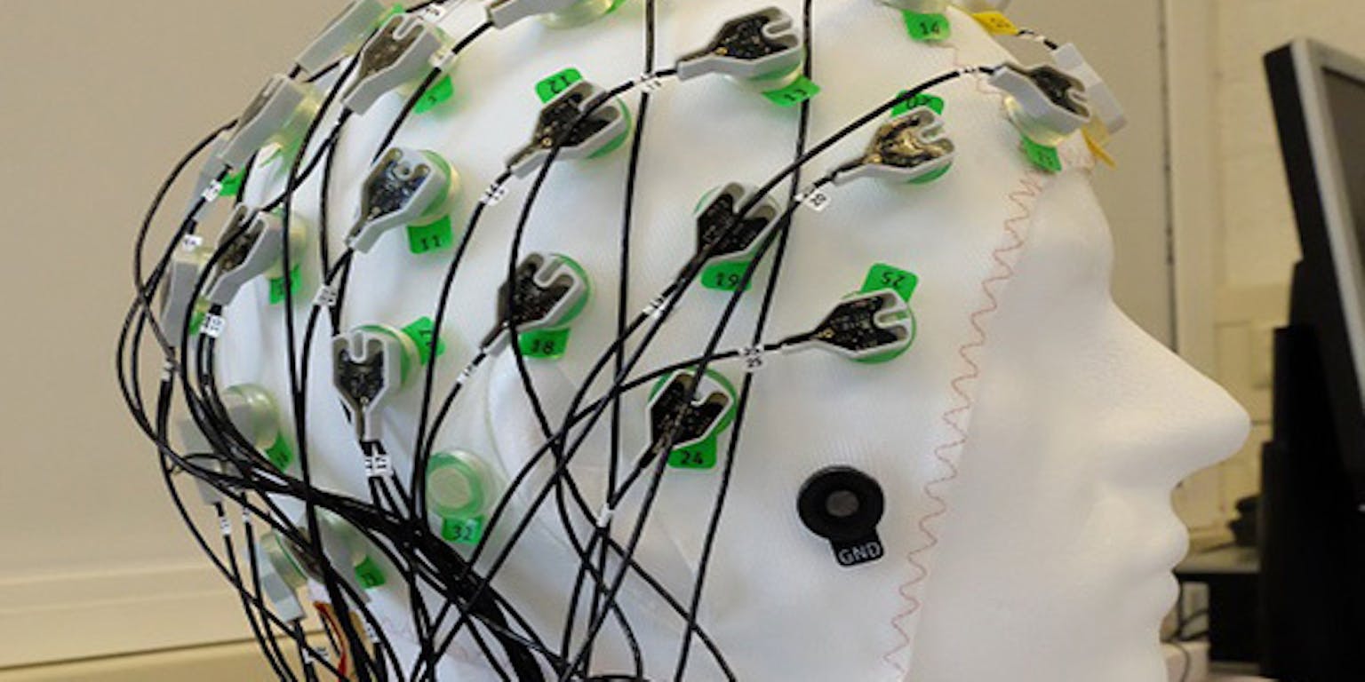 Een mannequinhoofd met daaraan bevestigde draden.