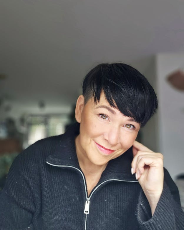 Dewi Groot ontdekte na een jarenlange zoektocht dat ze endometriose had. Portret van Dewi Groot, een witte vrouw met kort donker haar die glimlacht naar de camera