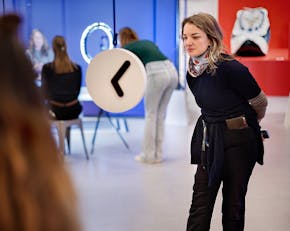 Een bezoeker van de tentoonstelling Living Looonger in De Studio van NEMO kijkt naar een klok.